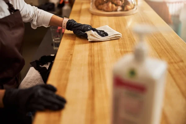 cafe-worker-cleaning-counter-with-cloth