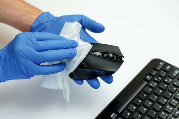 Person cleaning a computer mouse