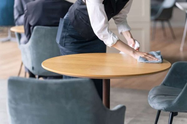 woman cleaning round table